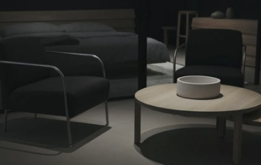 dark room with chairs and a table with a white pot